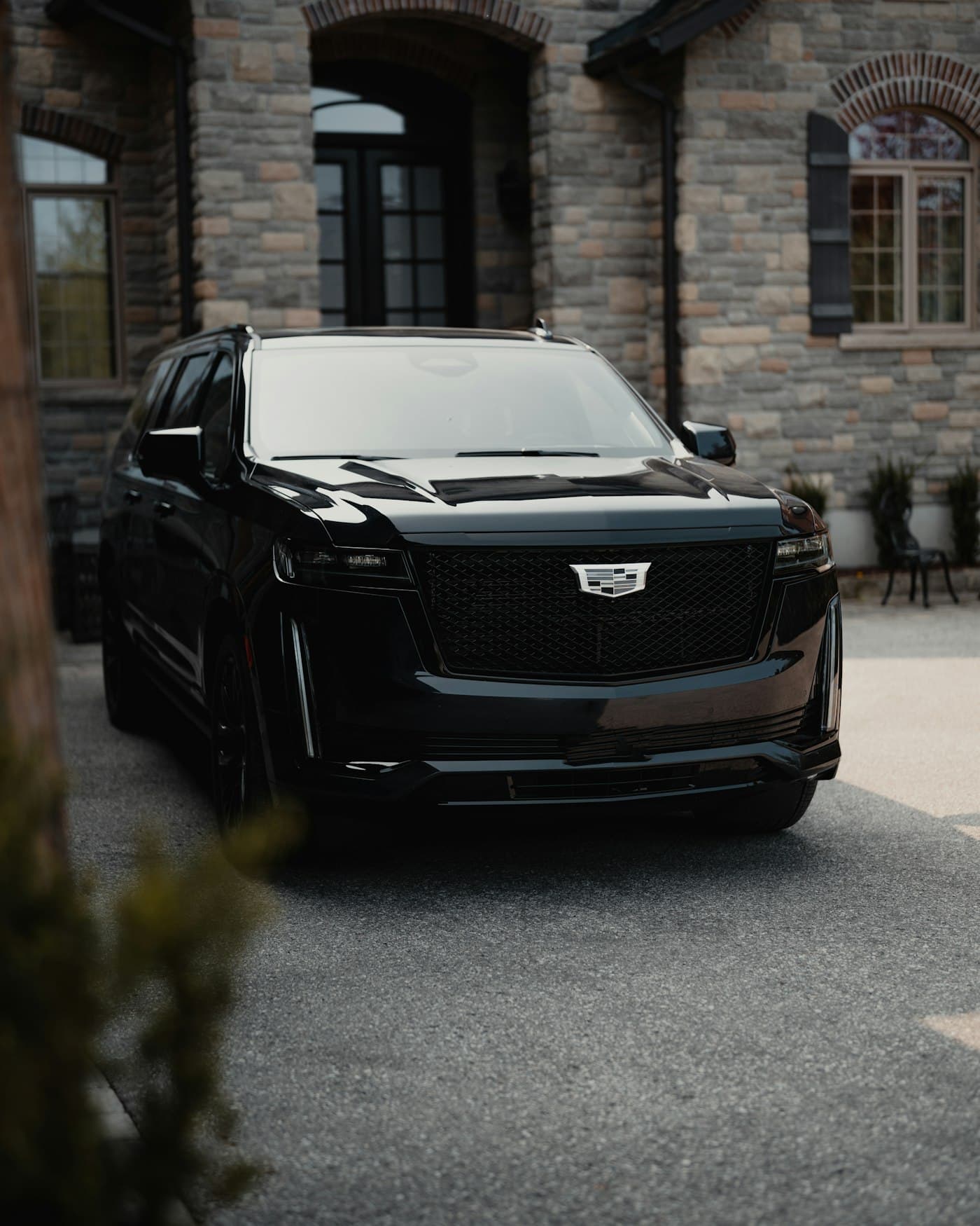 Black Cadillac Escalade parked at a Hamptons estate